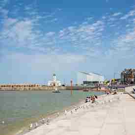 Looking along Margate defence steps to Turner Contemporary and harbour with a sailing yacht