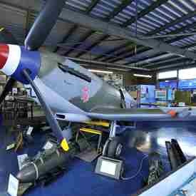 Spitfire Aircraft on display with memorabilia around it - pictures, artefacts, flags